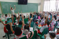 Kinder and elementary pupils of Pedro Cruz Elementary School join warm-up activities led by their teachers on the first day of classes, Monday, 16 June 2025.