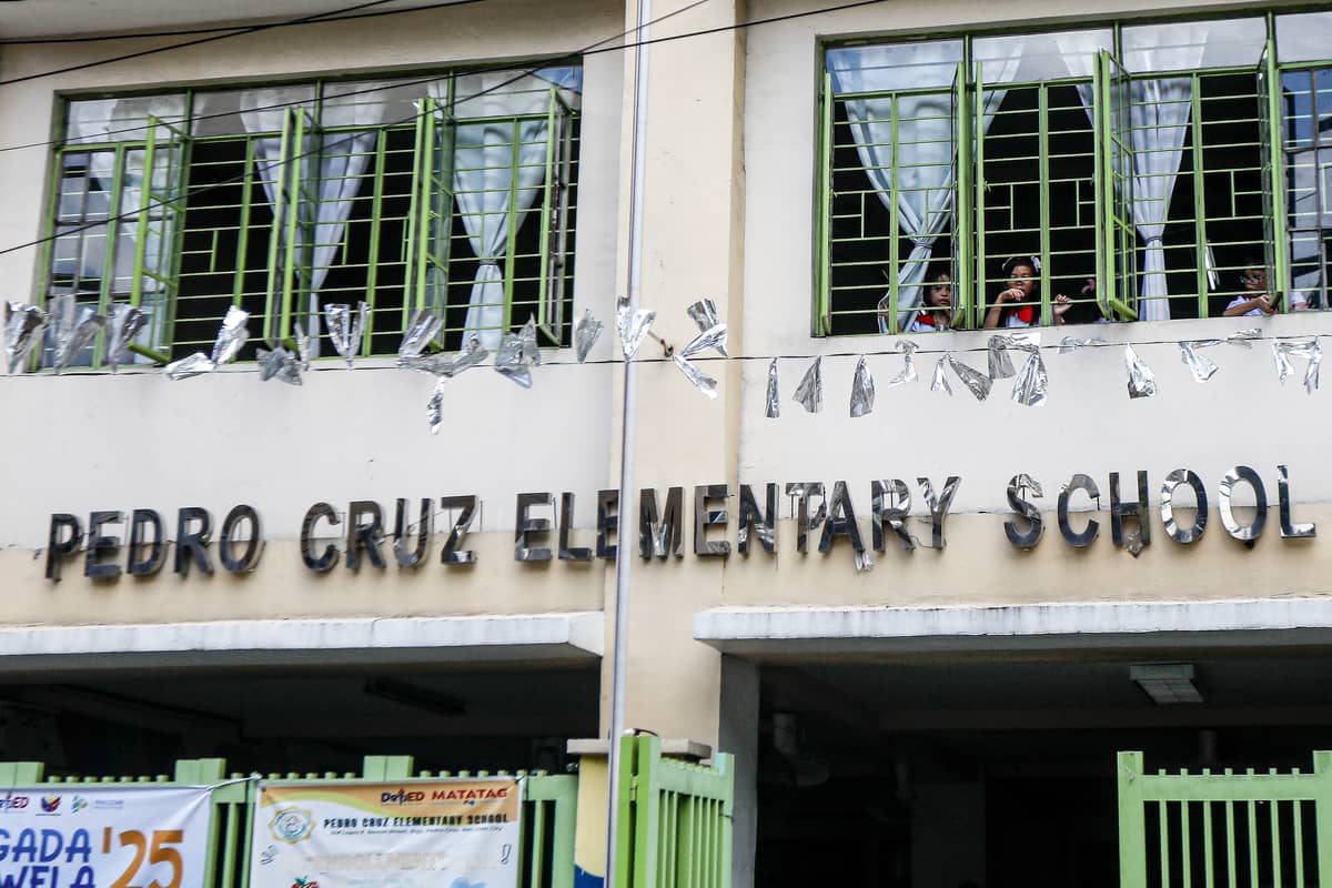 Kinder and elementary pupils of Pedro Cruz Elementary School join warm-up activities led by their teachers on the first day of classes, Monday, 16 June 2025.