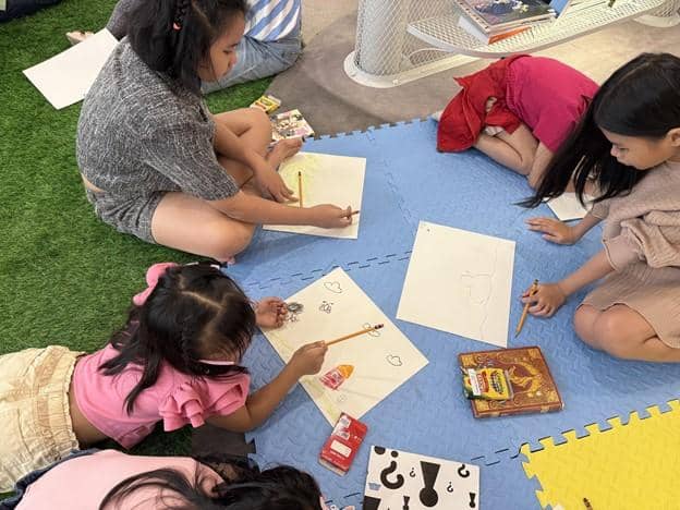 CHILDREN from Brgy. San Nicolas, Pasig City enjoy the “Read With Us” storytelling session at Book Nook Podium, featuring Nakisisilong—a Severino Reyes Medal-winning book.