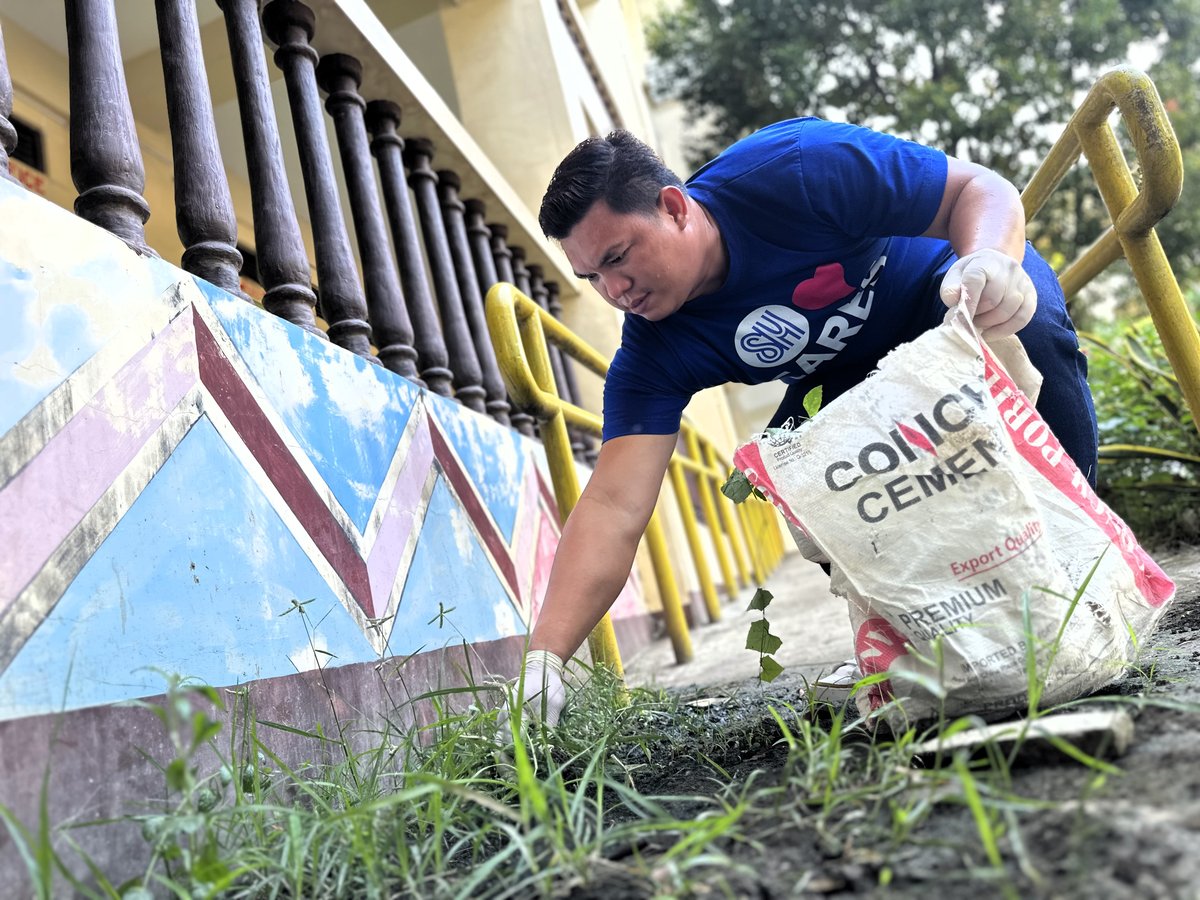 AN SM City Mindoro volunteer helps clean the school grounds during Brigada Eskwela — making way for brighter days and better learning.