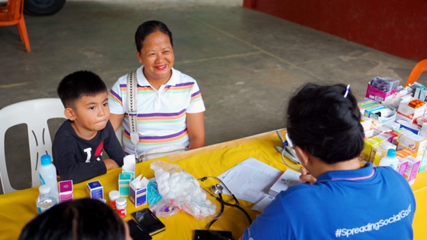 John David Cabral (left) and Lenny Cabral-Anciado attend the medical mission in Nasugbu, Batangas. (Inset) One of SM Foundation’s six mobile clinics sets off from SM City Tuguegarao en route to Cagayan.