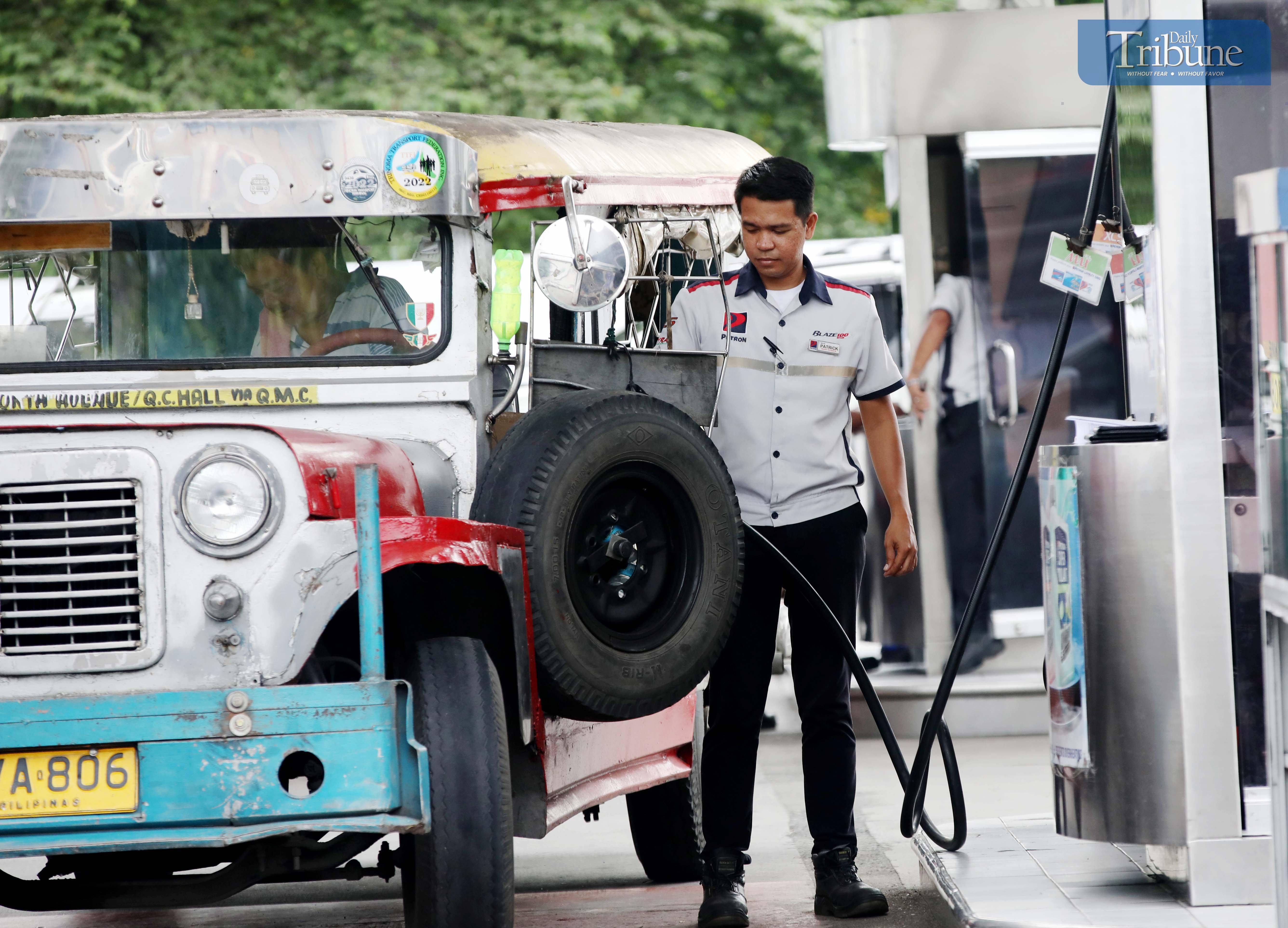 GAS station personnel assist motorists at a pump in Brgy. UP Central along Commonwealth Avenue, Quezon City, on Monday. The Department of Energy warned that diesel prices could surge by up to ₱5 per liter starting Tuesday, driven by rising global oil prices. Following a meeting with the DOE, oil companies agreed to implement the hike in staggered installments to ease the burden on consumers.