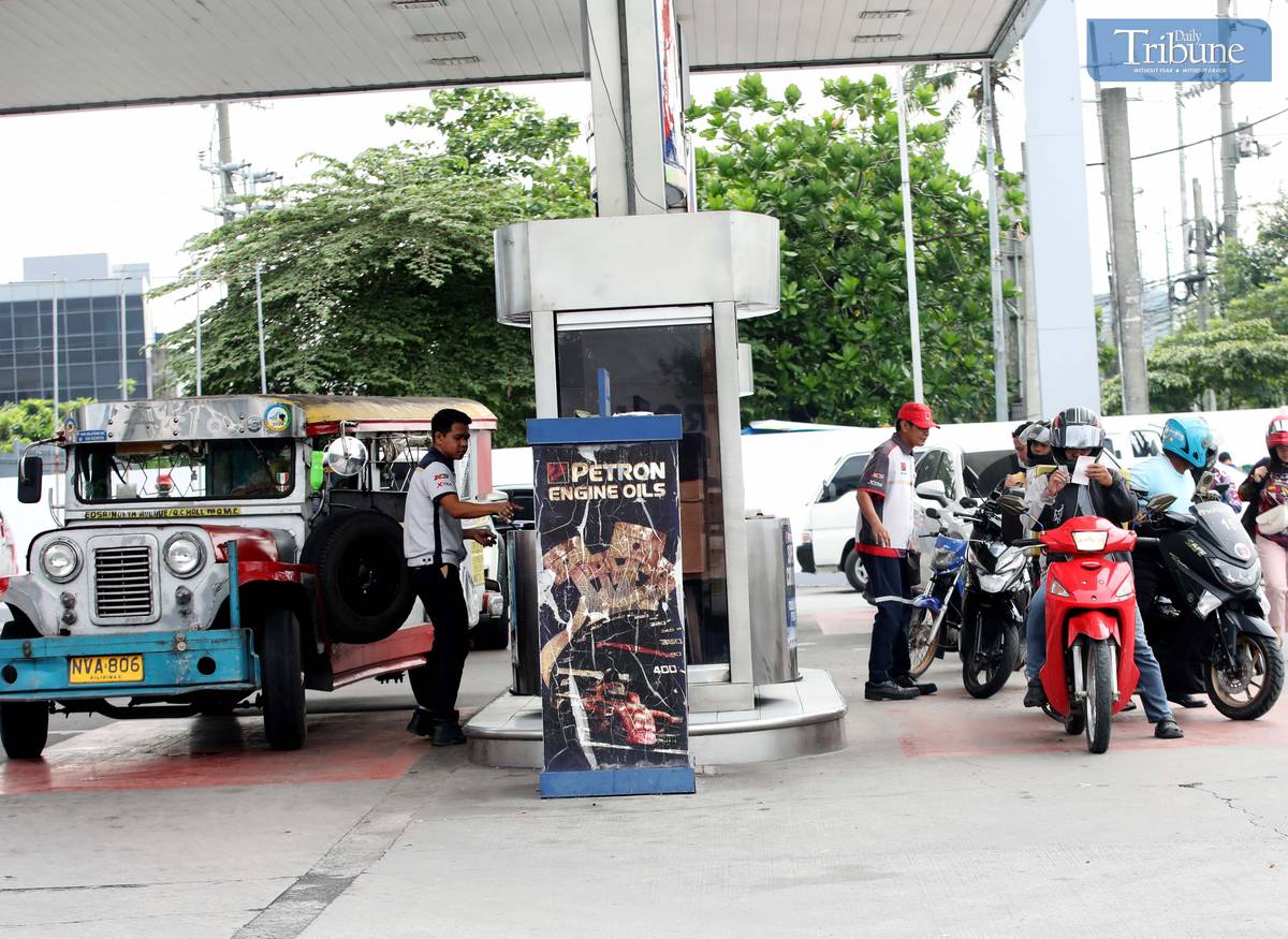 Gas station personnel assist motorists at a pump in Brgy. UP Central along Commonwealth Avenue, Quezon City, on Monday. The Department of Energy warned that diesel prices could surge by up to ₱5 per liter starting Tuesday, driven by rising global oil prices. Following a meeting with the DOE, oil companies agreed to implement the hike in staggered installments to ease the burden on consumers.
