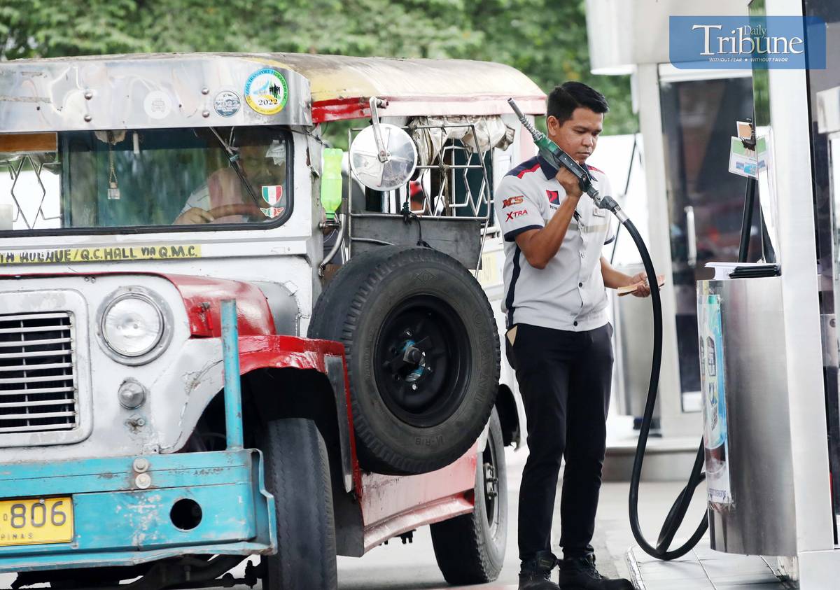 Gas station personnel assist motorists at a pump in Brgy. UP Central along Commonwealth Avenue, Quezon City, on Monday. The Department of Energy warned that diesel prices could surge by up to ₱5 per liter starting Tuesday, driven by rising global oil prices. Following a meeting with the DOE, oil companies agreed to implement the hike in staggered installments to ease the burden on consumers.