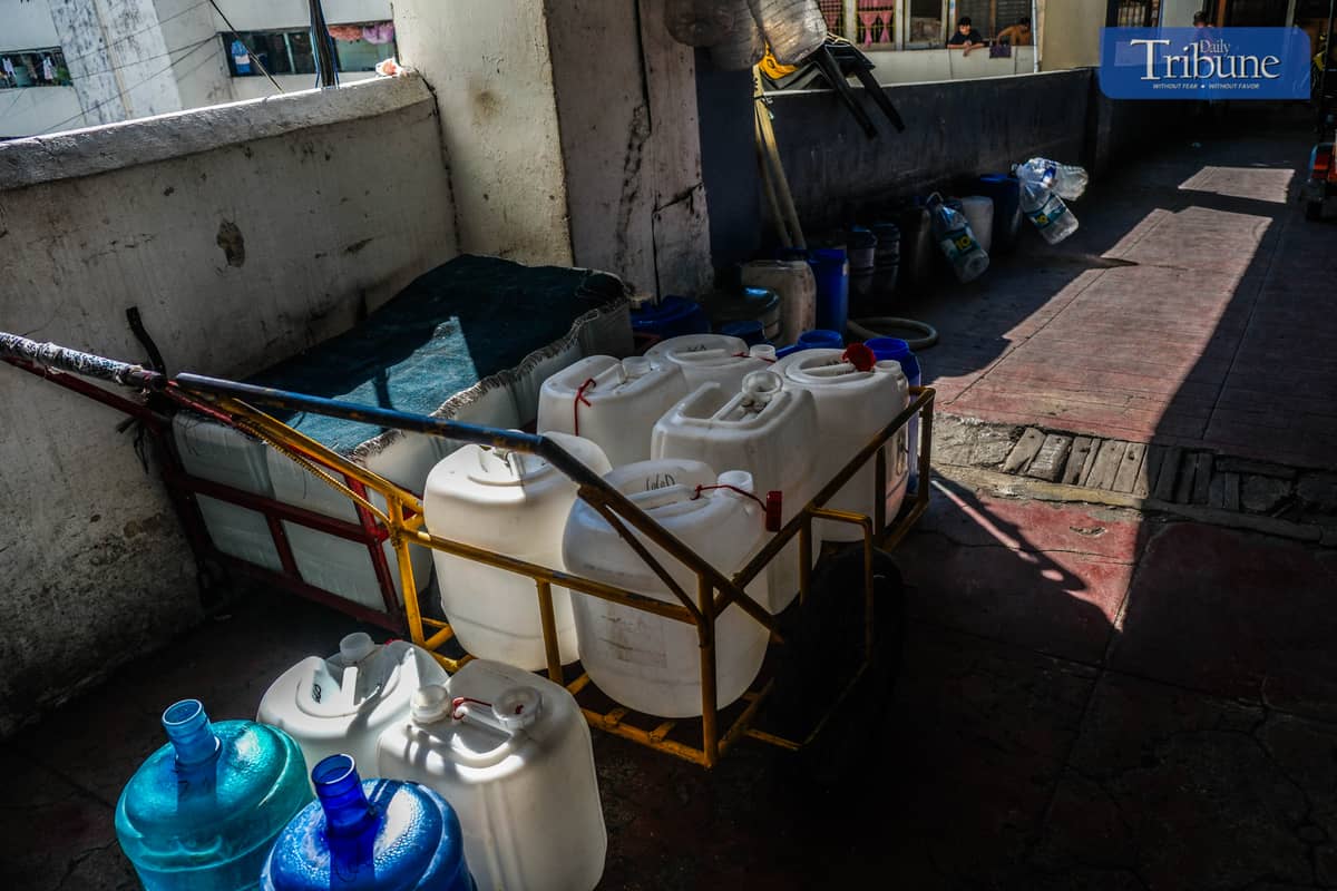 RESIDENTS of Tenement use push carts to carry gallons of water as water isn't accessible. PHOTO BY YUMMIE DINGDING