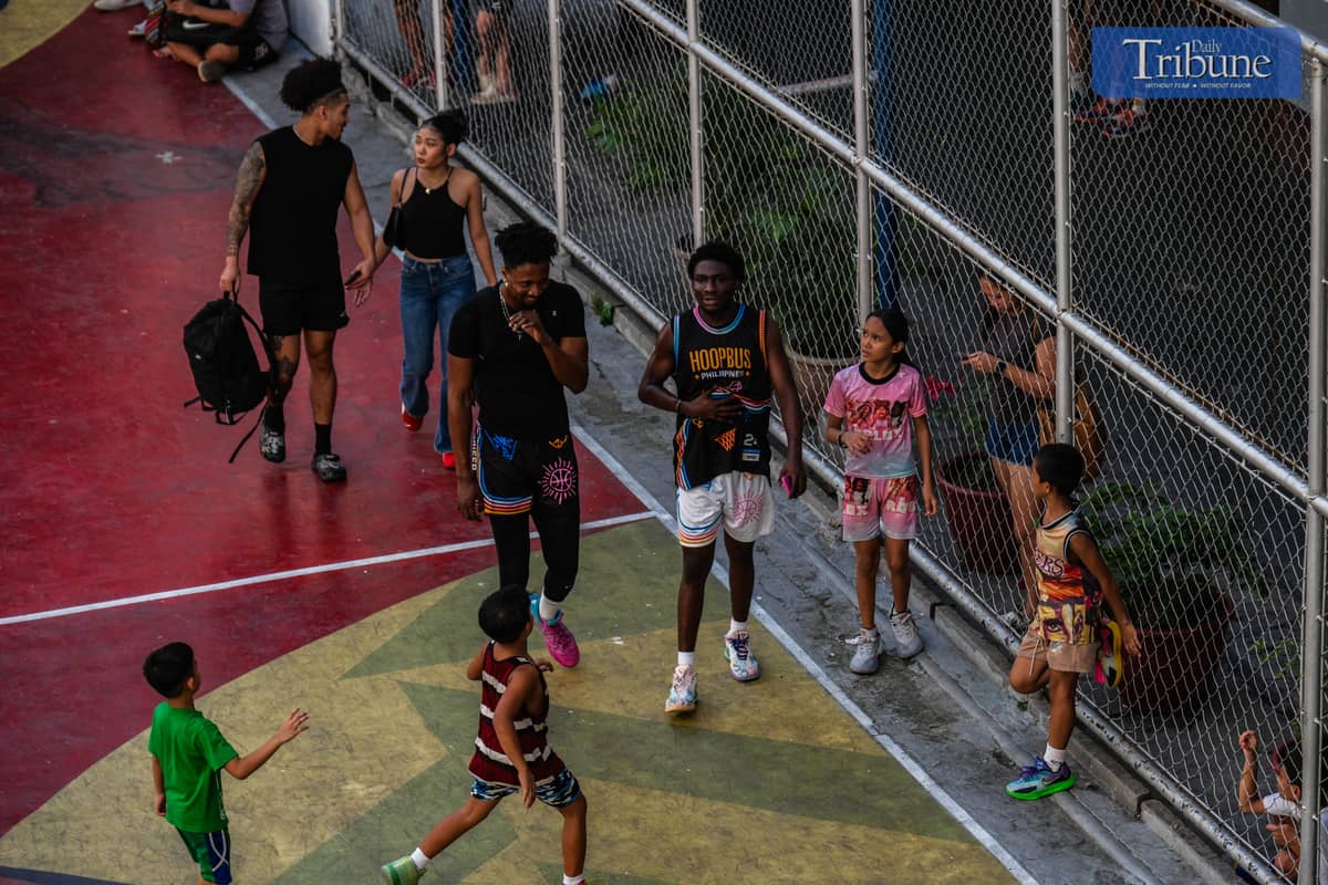 TENEMENT kids meet collegian basketball players who come to play at the court during Picnic Games. PHOTO BY YUMMIE DINGDING