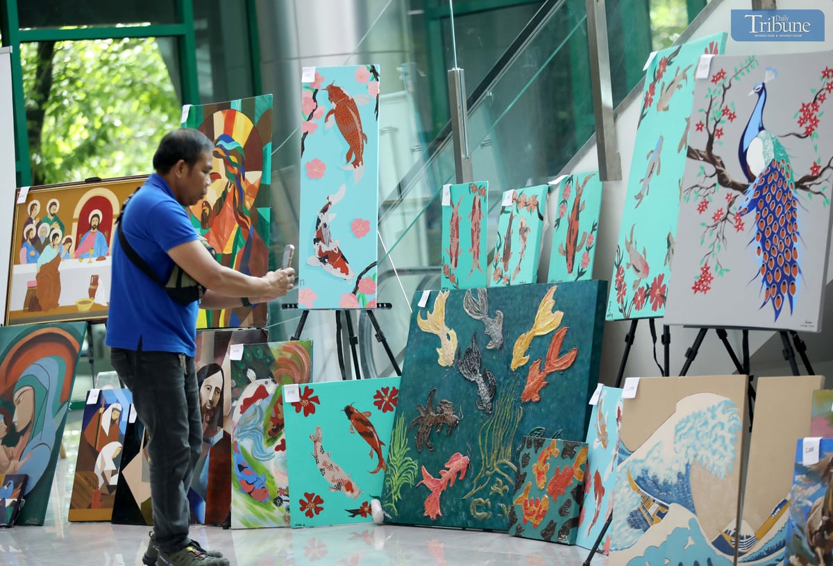 A man photographs a painting made by a person deprived of liberty (PDL), displayed at the M.I.C.E. Building in Quezon City Hall on Wednesday, July 2, 2025. The artwork, showcased during the Bureau of Jail Management and Penology’s (BJMP) 34th anniversary celebration, is being sold to raise funds for PDL artists and their families.