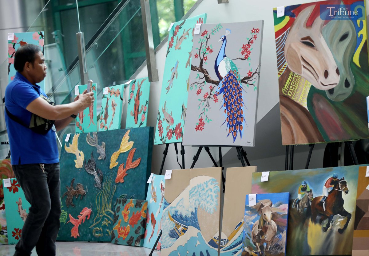 A man photographs a painting made by a person deprived of liberty (PDL), displayed at the M.I.C.E. Building in Quezon City Hall on Wednesday, July 2, 2025. The artwork, showcased during the Bureau of Jail Management and Penology’s (BJMP) 34th anniversary celebration, is being sold to raise funds for PDL artists and their families.