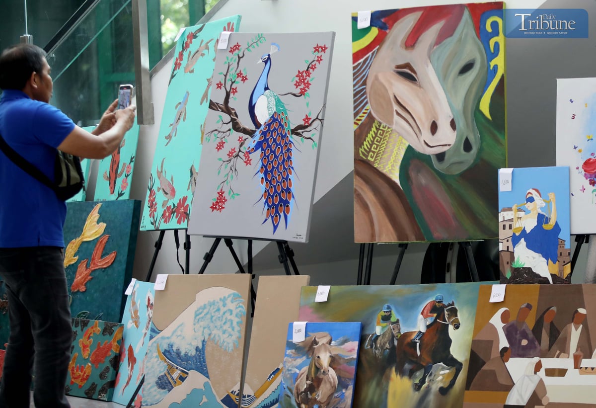 A man photographs a painting made by a person deprived of liberty (PDL), displayed at the M.I.C.E. Building in Quezon City Hall on Wednesday, July 2, 2025. The artwork, showcased during the Bureau of Jail Management and Penology’s (BJMP) 34th anniversary celebration, is being sold to raise funds for PDL artists and their families.