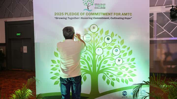 A SUPPORTER of the Annual Million Trees Challenge sticks his organization’s logo on the pledging board during the AMTC Recognition and Awarding ceremony on 2 July at the Celebrity Club in Quezon City.