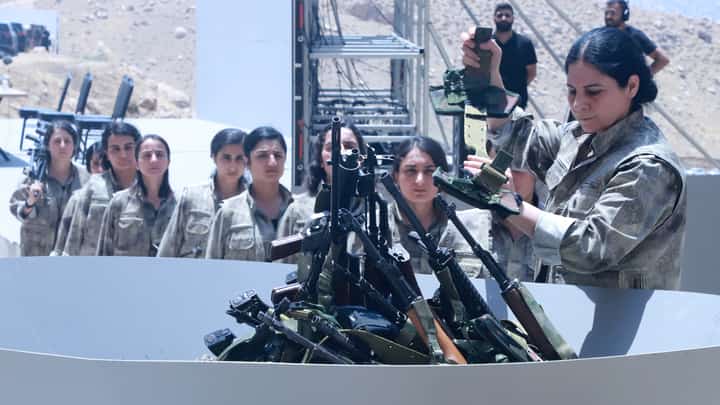 Fighters with the Kurdistan Workers' Party (PKK) line up to put their weapons into a pit during a ceremony in Sulaimaniyah, in Iraq's autonomous Kurdistan region, on July 11, 2025. Thirty PKK fighters destroyed their weapons at a ceremony in Iraqi Kurdistan on July 11, two months after the Kurdish rebels ended their decades-long armed struggle against the Turkish state.