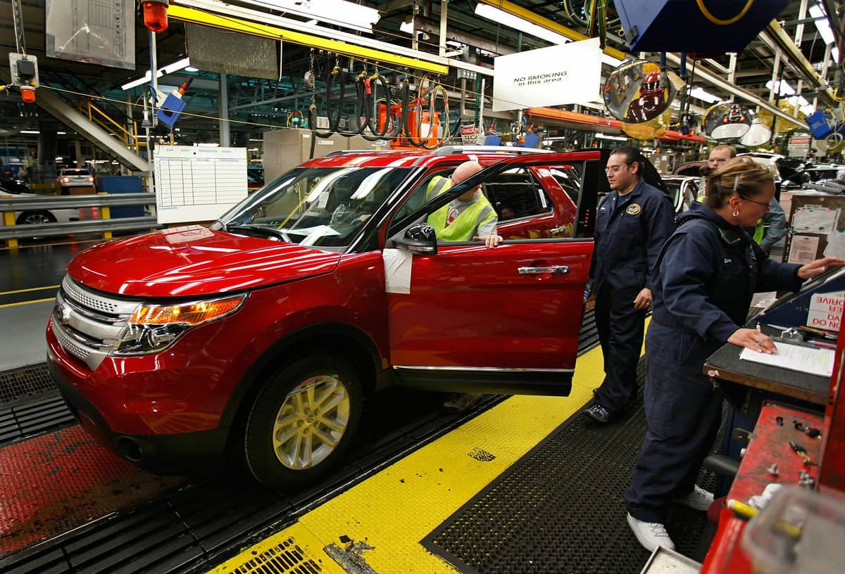 FORD workers on the assembly line inspect a newly built Explorer, one of the vehicles included in the fuel pump recall.