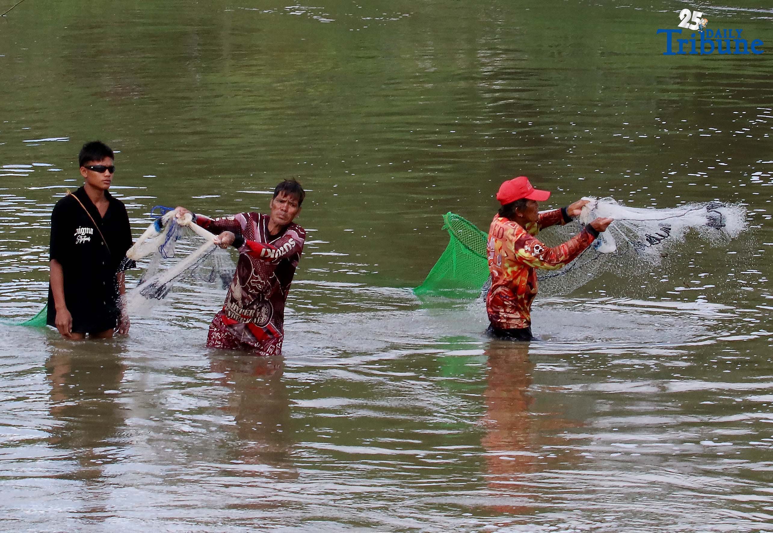Fishers in Santa Maria, Bulacan cast traditional nets into the Macaiban Floodway to catch freshwater tilapia—sustaining both their livelihood and daily food supply.