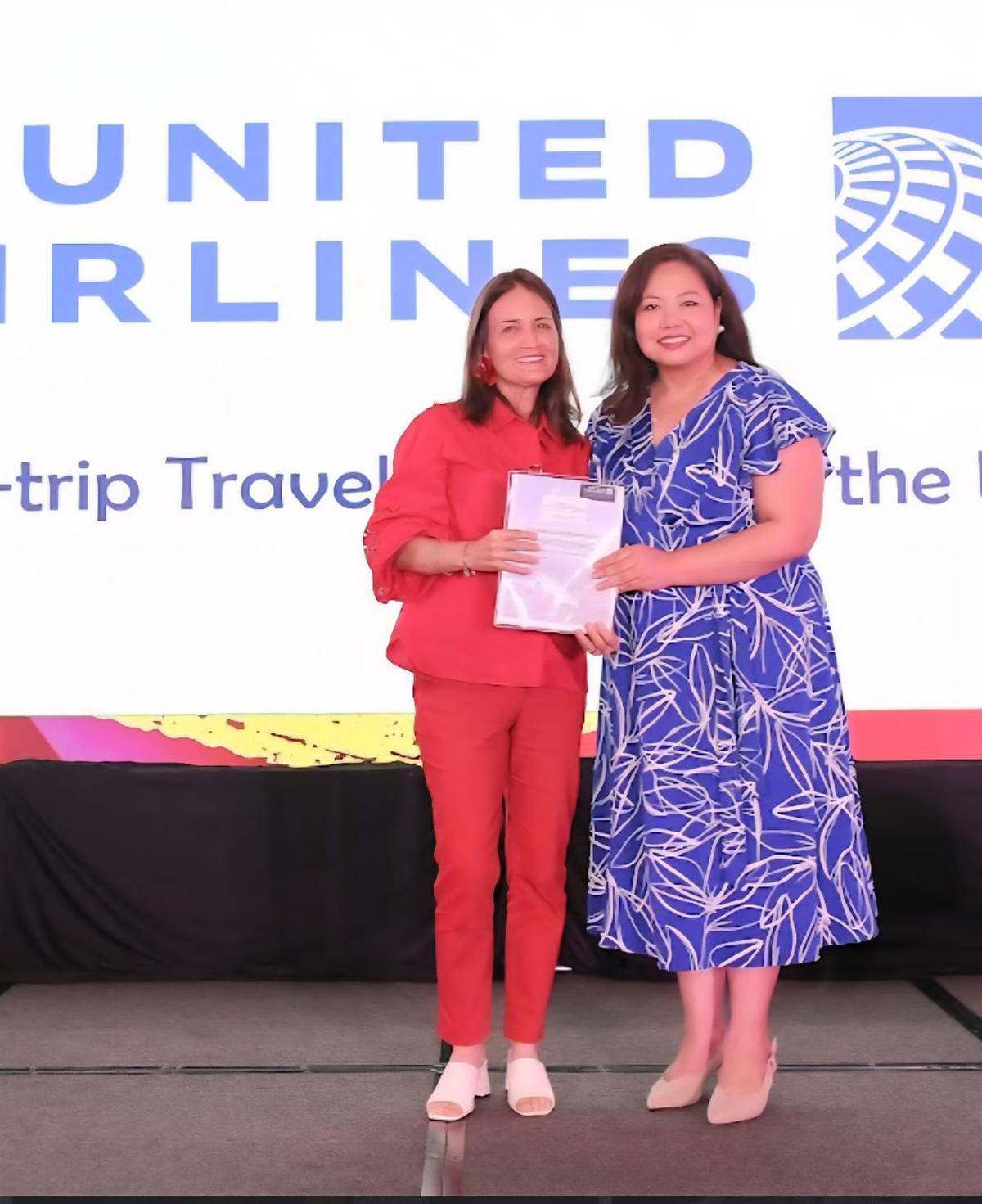 Pam Navarro, country manager of United Airlines Philippines, hands over the round trip ticket to the USA to Maripaz Perdices.