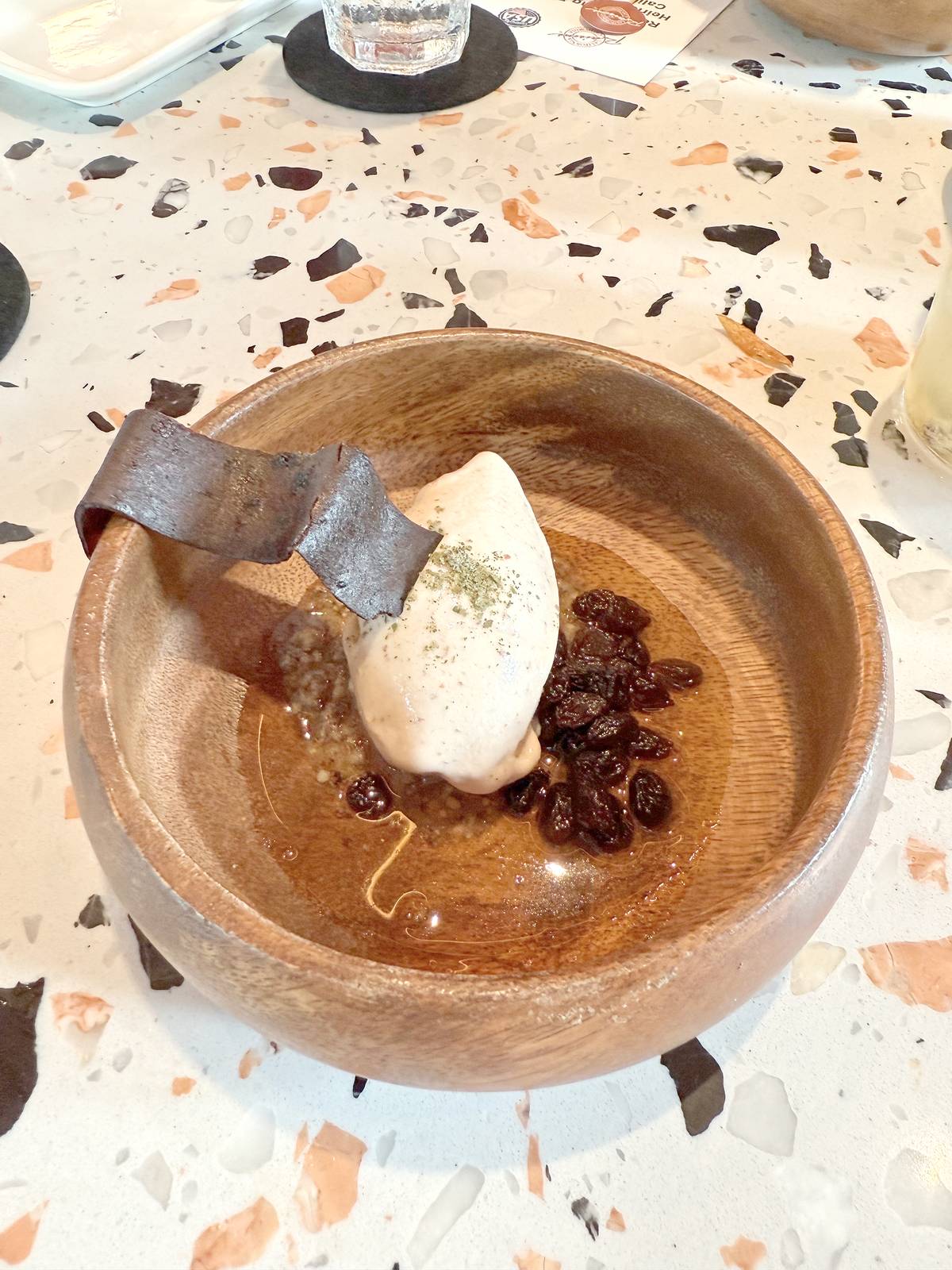 California Raisins Milk Ice Cream with Milk Tuile and Burnt California Raisin Paste Oil.