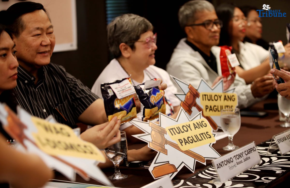 Members of Tindig Pilipinas, the Nagkaisa Labor Coalition, and Akbayan hold a box filled with junk food labeled with satirical names like “Piattos” — a jab at alleged recipients of the Office of the Vice President’s confidential funds — during a press conference in Quezon City on Thursday. The groups are calling for the immediate start of Vice President Sara Duterte’s impeachment trial over alleged misuse of confidential funds, supposed involvement in murder plots, and betrayal of public trust.