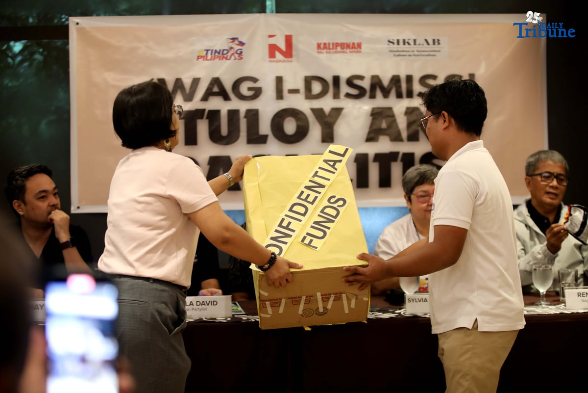 Members of Tindig Pilipinas, the Nagkaisa Labor Coalition, and Akbayan hold a box filled with junk food labeled with satirical names like “Piattos” — a jab at alleged recipients of the Office of the Vice President’s confidential funds — during a press conference in Quezon City on Thursday. The groups are calling for the immediate start of Vice President Sara Duterte’s impeachment trial over alleged misuse of confidential funds, supposed involvement in murder plots, and betrayal of public trust.