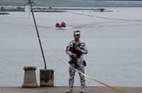 A PHILIPPINE Coast Guard serviceman keeps watch at a pier in Taal Lake near Laurel town, Batangas province where authorities search for missing cockfighters.