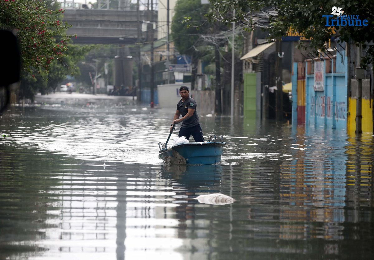 A man uses a small boat to cross floodwaters at N.S. Amoranto Street corner Araneta Avenue in Quezon City on Saturday, 19 July 2025, after continuous rains brought by the Habagat intensified by Severe Tropical Storm Crising.