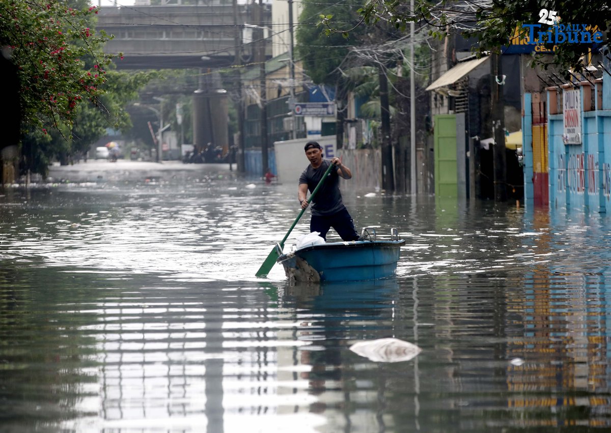 A man uses a small boat to cross floodwaters at N.S. Amoranto Street corner Araneta Avenue in Quezon City on Saturday, 19 July 2025, after continuous rains brought by the Habagat intensified by Severe Tropical Storm Crising.