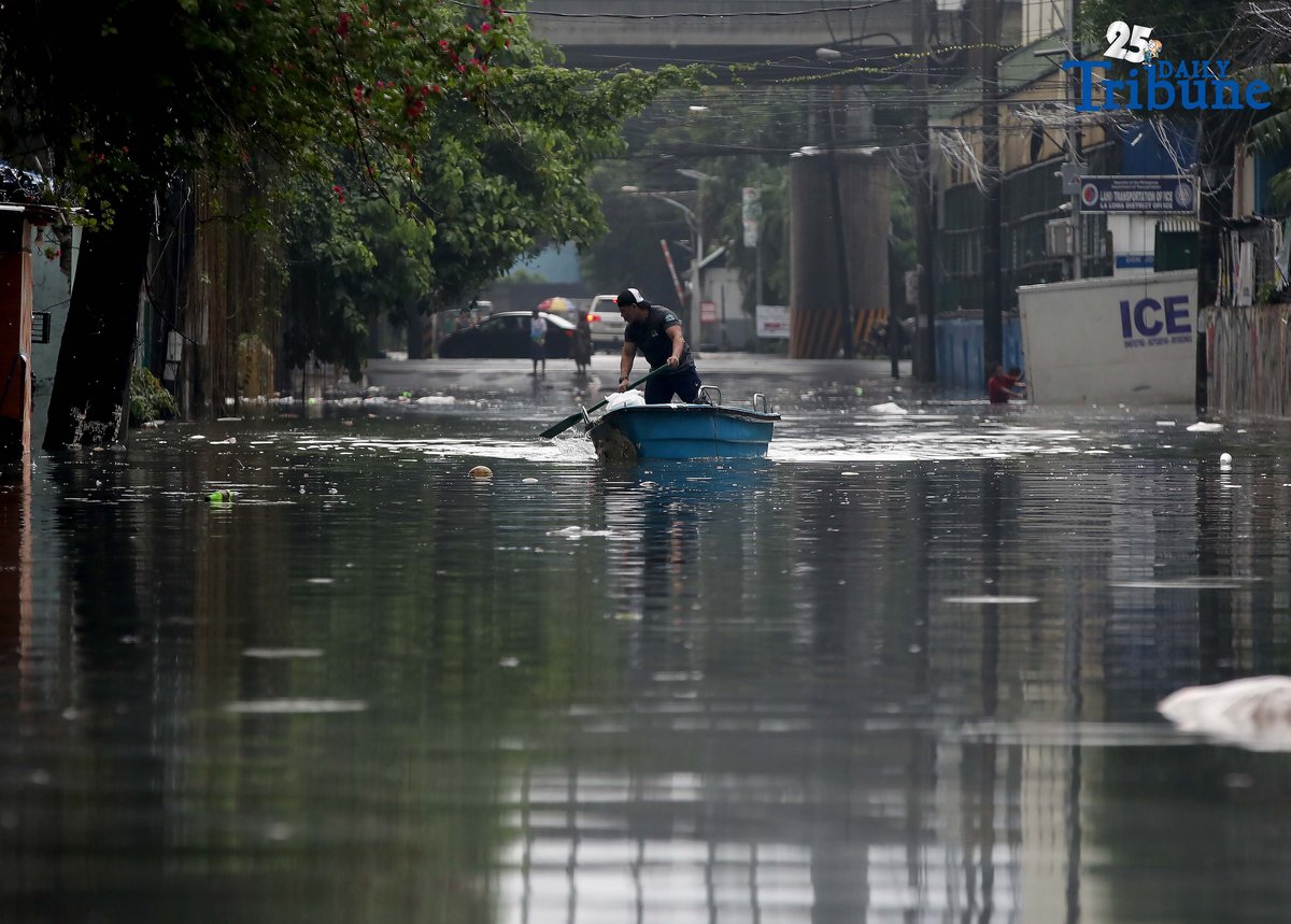 A man uses a small boat to cross floodwaters at N.S. Amoranto Street corner Araneta Avenue in Quezon City on Saturday, 19 July 2025, after continuous rains brought by the Habagat intensified by Severe Tropical Storm Crising.