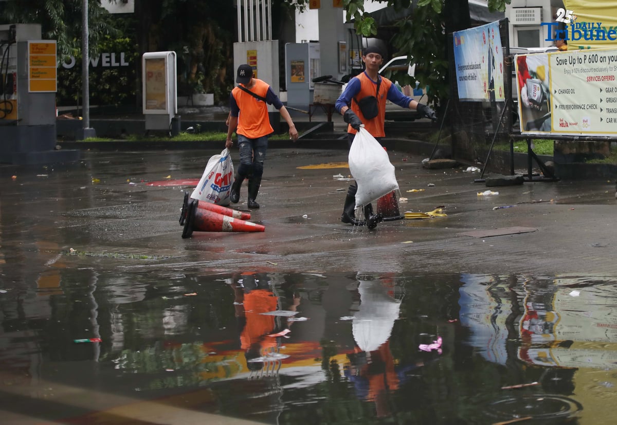 Department of Public Works and Highways (DPWH) personnel collect garbage washed up by floodwaters along Araneta Avenue in Quezon City on Saturday, 19 July 2025, following heavy rainfall.