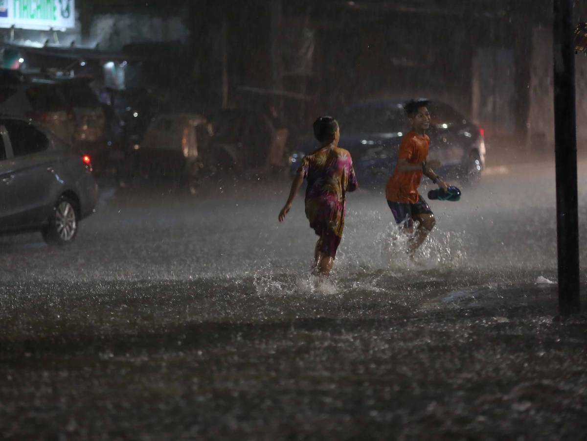 YOUNG boys enjoy playing at the flooded area along Edsa corner Kamias Road in Quezon City, on 16 July 2022, after a heavy downpour.