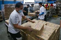 VOLUNTEERS at the DSWD-National Resource Operations Center in Pasay City prepare relief goods for areas affected by tropical storm “Crising.” The agency has prepositioned supplies nationwide to ensure timely response.