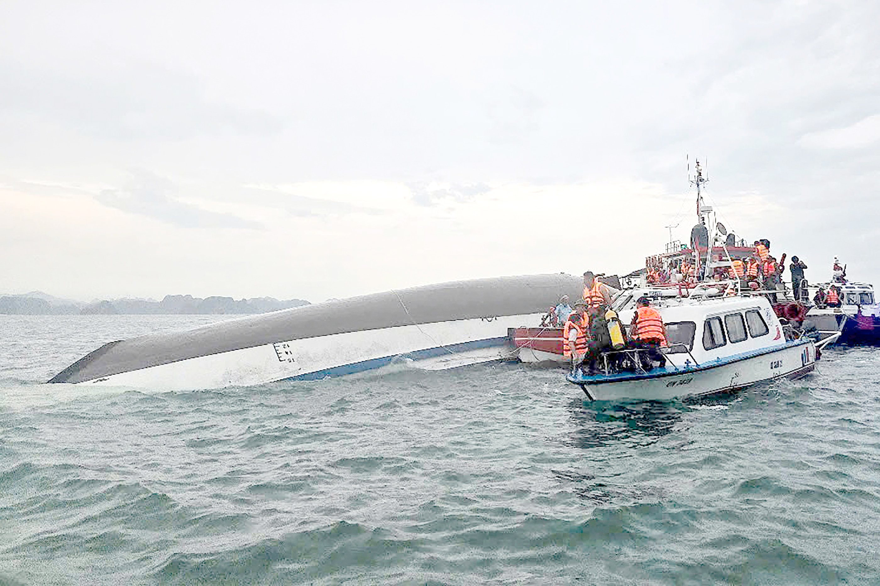 Rescuers personnel gather around a capsized tourist boat in the Ha Long Bay, Quang Ninh province.
