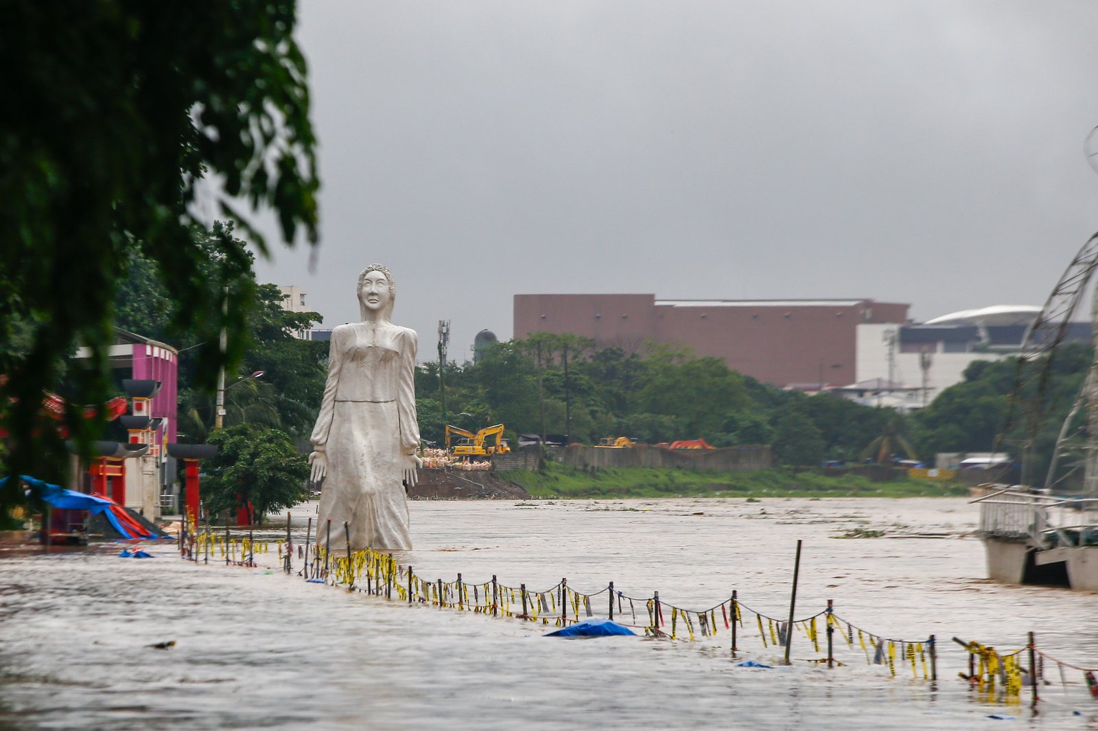 Residents monitor the water level of the Marikina River as it hits the second alarm at 3:00 in the afternoon of 21 July 2025 due to heavy rains brought by Habagat.