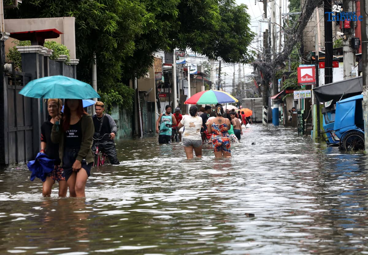 Residents in Barangay Rincon, Valenzuela City wade through flooded roads on July 22, 2025, as continuous rains submerge parts of the area. The southwest monsoon, or habagat, is expected to bring more moderate to heavy rainfall across Metro Manila, Luzon, and parts of the Visayas over the next three days, according to PAGASA.
