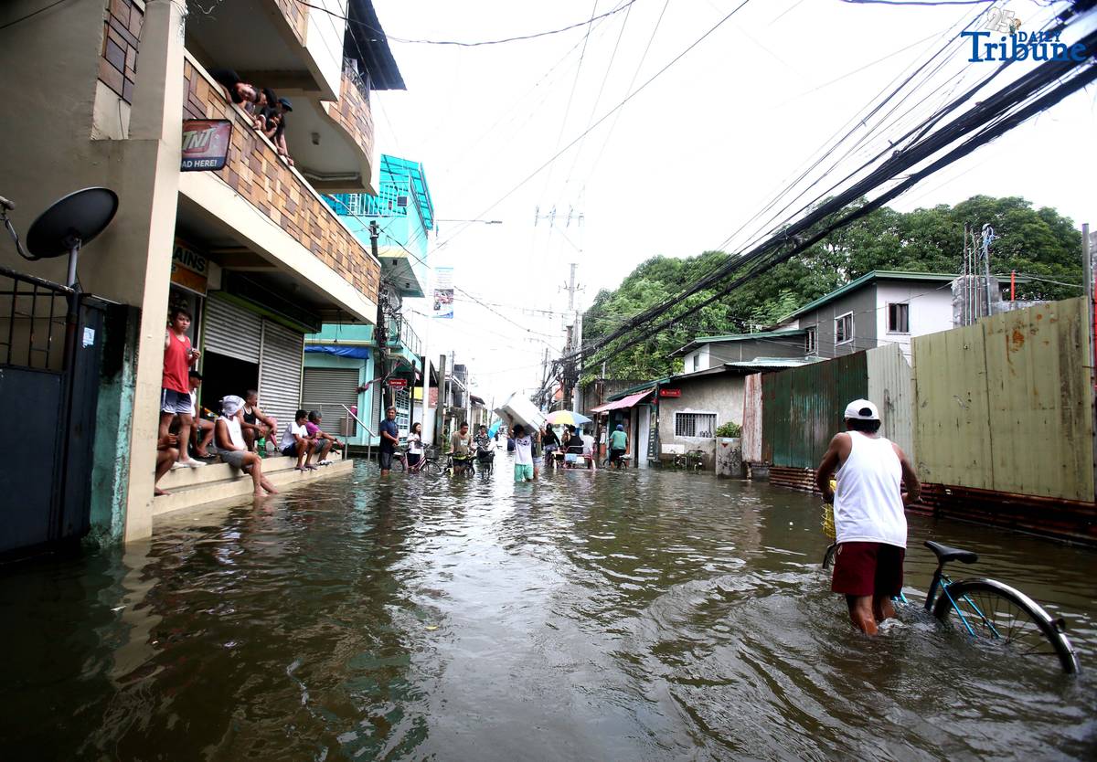 Residents in Barangay Rincon, Valenzuela City wade through flooded roads on July 22, 2025, as continuous rains submerge parts of the area. The southwest monsoon, or habagat, is expected to bring more moderate to heavy rainfall across Metro Manila, Luzon, and parts of the Visayas over the next three days, according to PAGASA.