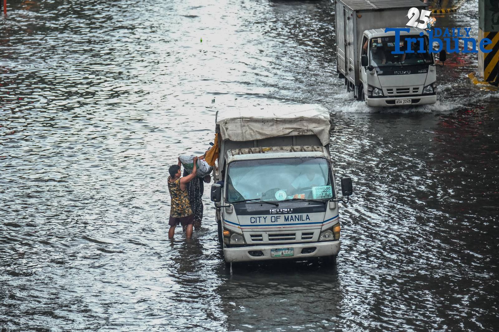 Commuters go about their day in Manila despite the unrelenting downpour.