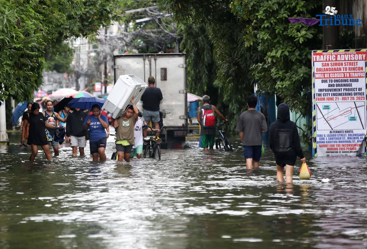 Residents in Barangay Rincon, Valenzuela City wade through flooded roads on July 22, 2025, as continuous rains submerge parts of the area. The southwest monsoon, or habagat, is expected to bring more moderate to heavy rainfall across Metro Manila, Luzon, and parts of the Visayas over the next three days, according to PAGASA.