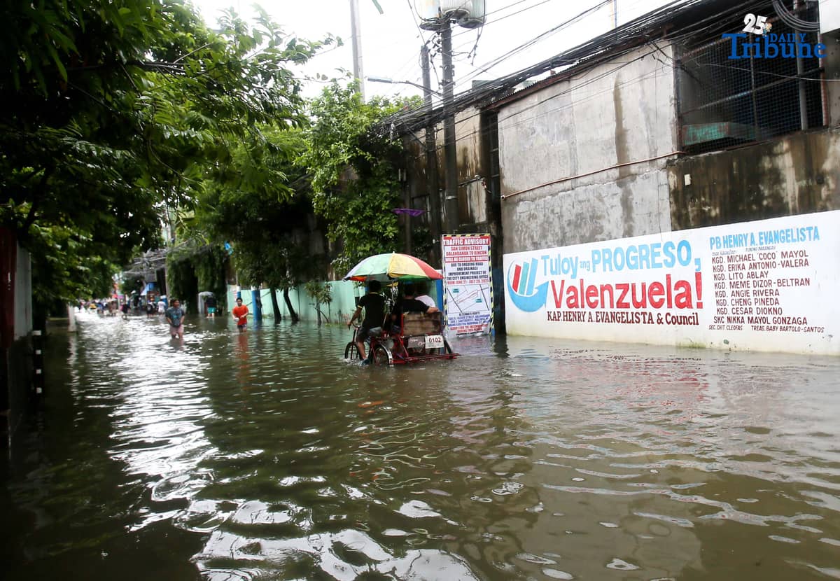 Residents in Barangay Rincon, Valenzuela City wade through flooded roads on July 22, 2025, as continuous rains submerge parts of the area. The southwest monsoon, or habagat, is expected to bring more moderate to heavy rainfall across Metro Manila, Luzon, and parts of the Visayas over the next three days, according to PAGASA.