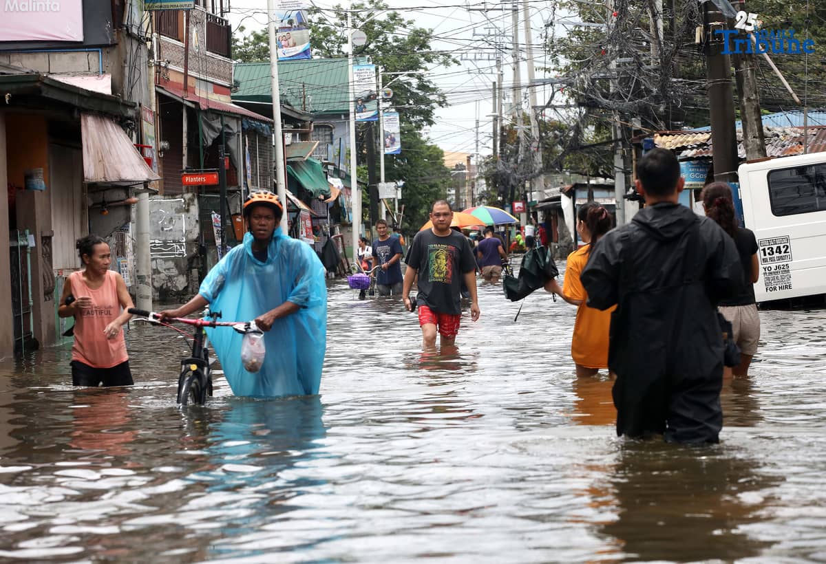 Residents in Barangay Rincon, Valenzuela City wade through flooded roads on July 22, 2025, as continuous rains submerge parts of the area. The southwest monsoon, or habagat, is expected to bring more moderate to heavy rainfall across Metro Manila, Luzon, and parts of the Visayas over the next three days, according to PAGASA.