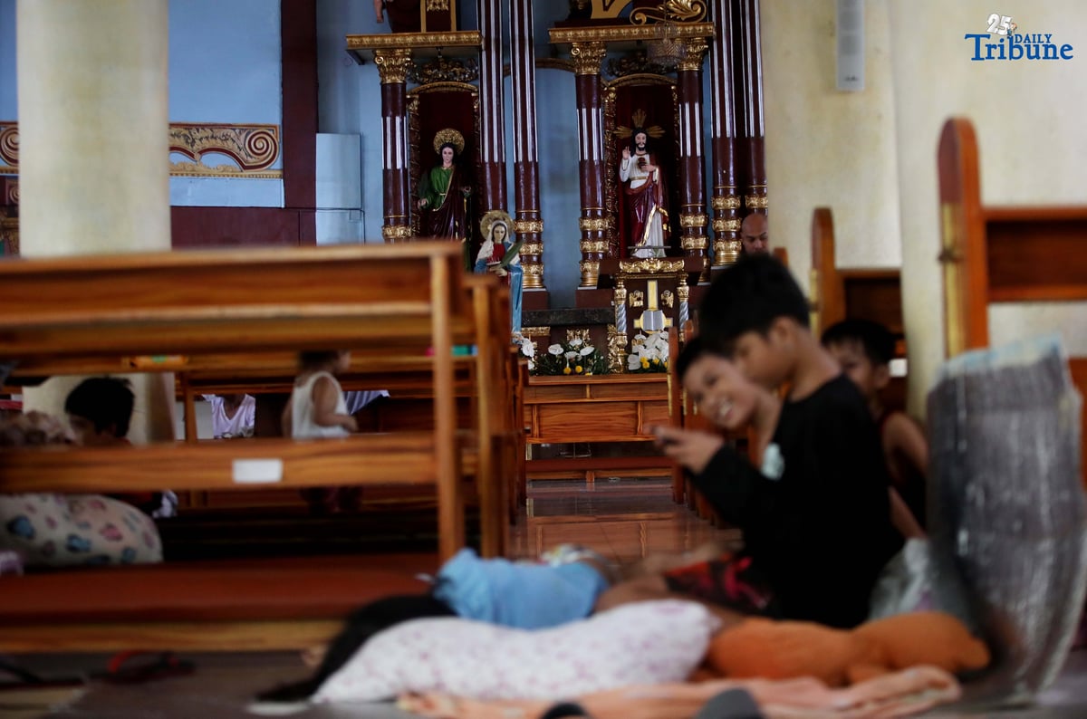 Evacuees take temporary shelter at Santa Lucia Parish in Barangay Sta. Lucia, Novaliches, Quezon City on Tuesday, July 22, 2025, after rising waters from Tullahan River submerged homes amid nonstop rains brought by the southwest monsoon.