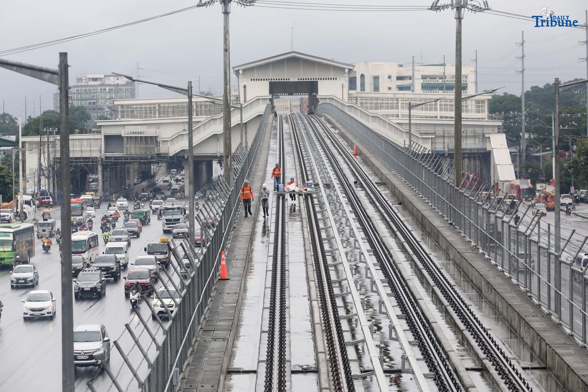 MRT-7 workers walk along the train tracks near Batasan Station on Commonwealth Avenue, Quezon City, on Wednesday, July 23, 2025. The 22-kilometer elevated railway project—connecting Metro Manila and Bulacan through 14 stations—is now 83.08% complete. Trial runs are expected to begin by the end of 2025, with full operations targeted for 2026 and a projected daily ridership of 600,000.