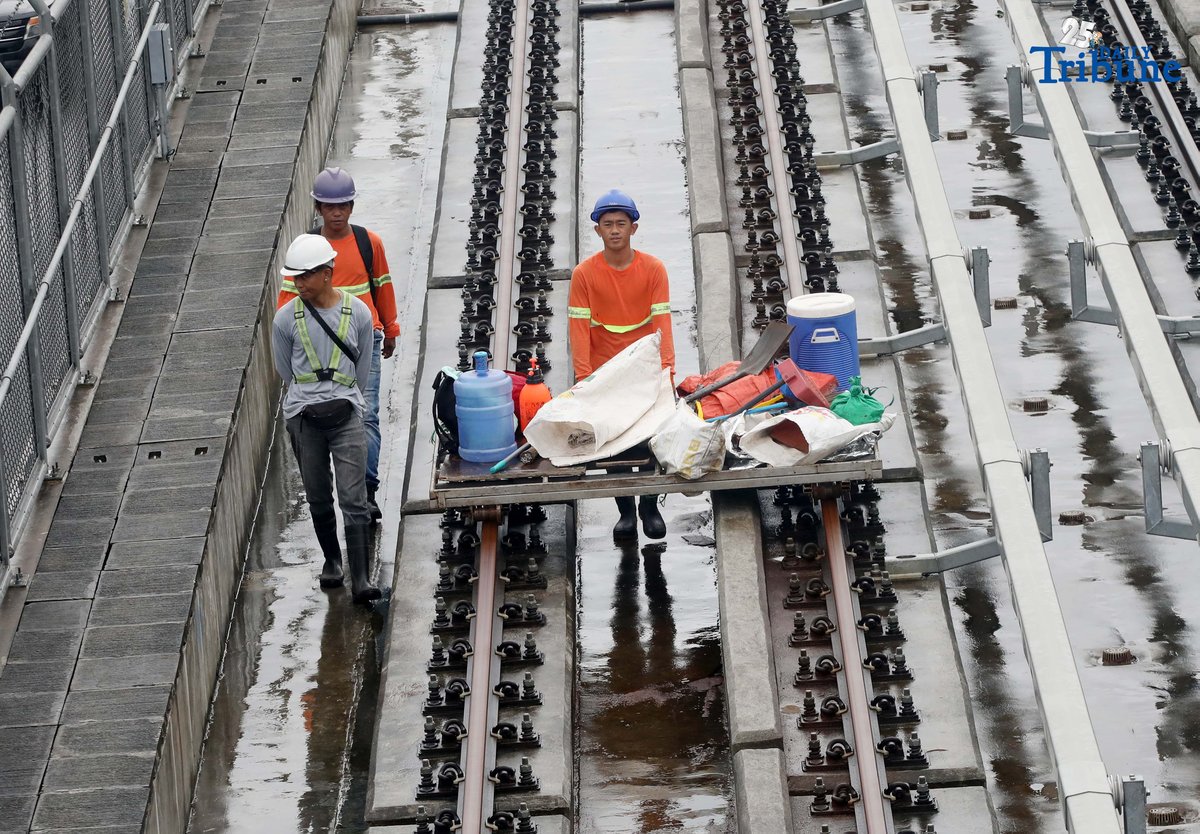 MRT-7 workers walk along the train tracks near Batasan Station on Commonwealth Avenue, Quezon City, on Wednesday, July 23, 2025. The 22-kilometer elevated railway project—connecting Metro Manila and Bulacan through 14 stations—is now 83.08% complete. Trial runs are expected to begin by the end of 2025, with full operations targeted for 2026 and a projected daily ridership of 600,000.