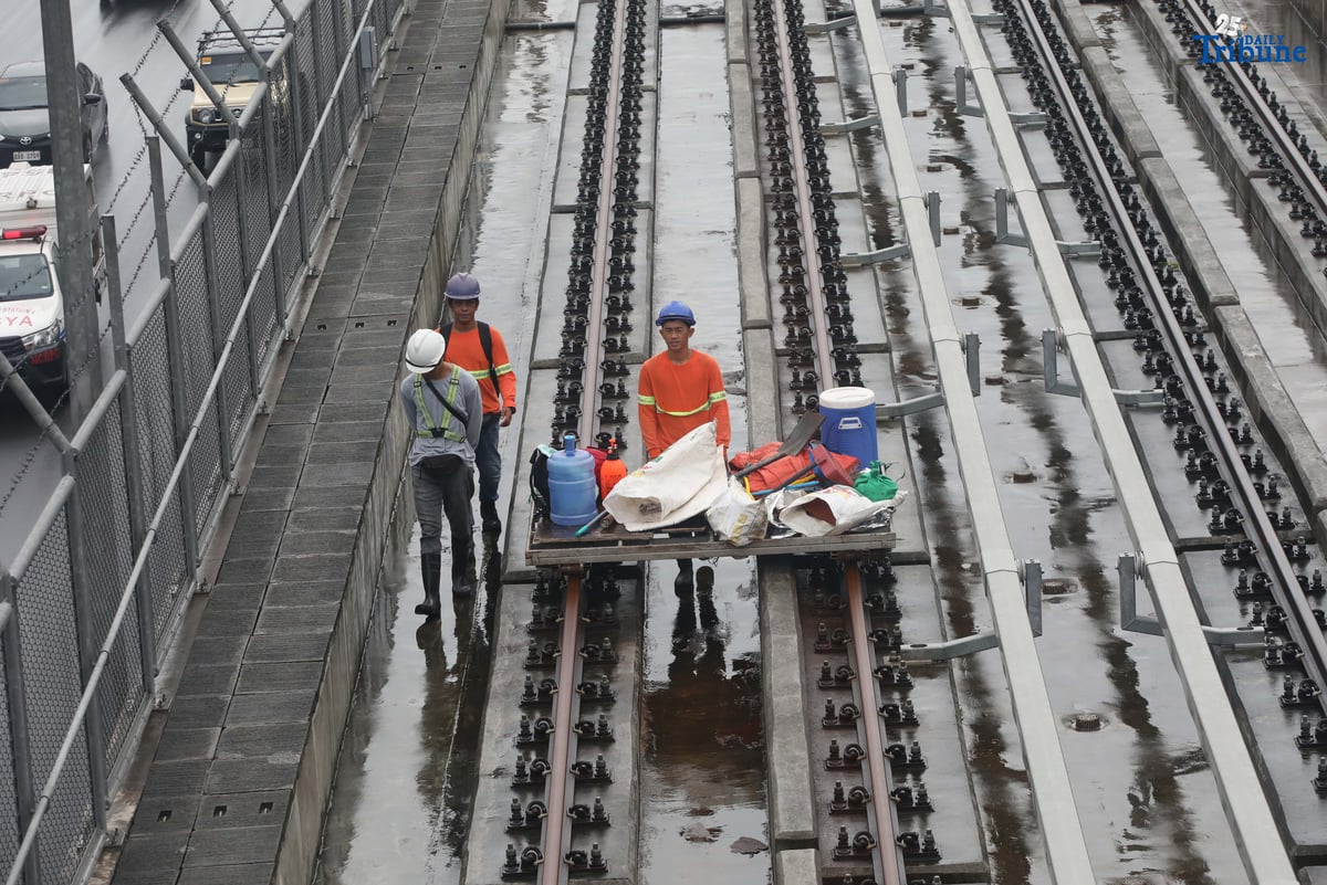 MRT-7 workers walk along the train tracks near Batasan Station on Commonwealth Avenue, Quezon City, on Wednesday, July 23, 2025. The 22-kilometer elevated railway project—connecting Metro Manila and Bulacan through 14 stations—is now 83.08% complete. Trial runs are expected to begin by the end of 2025, with full operations targeted for 2026 and a projected daily ridership of 600,000.