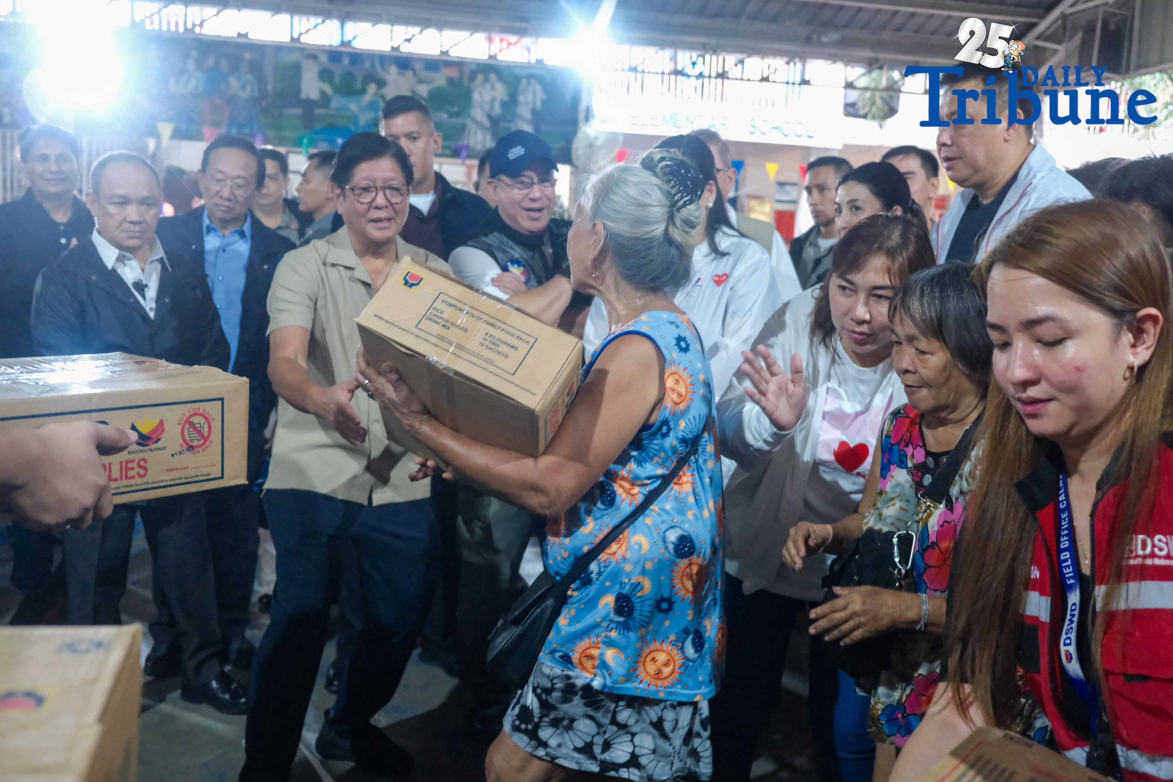 President Ferdinand Marcos Jr. helps an elderly evacuee carry a relief kit from DSWD during his visit at Maly Elementary School in San Mateo, Rizal, on Thursday, July 24, 2025. PHOTO BY YUMMIE DINGDING / PPA POOL
