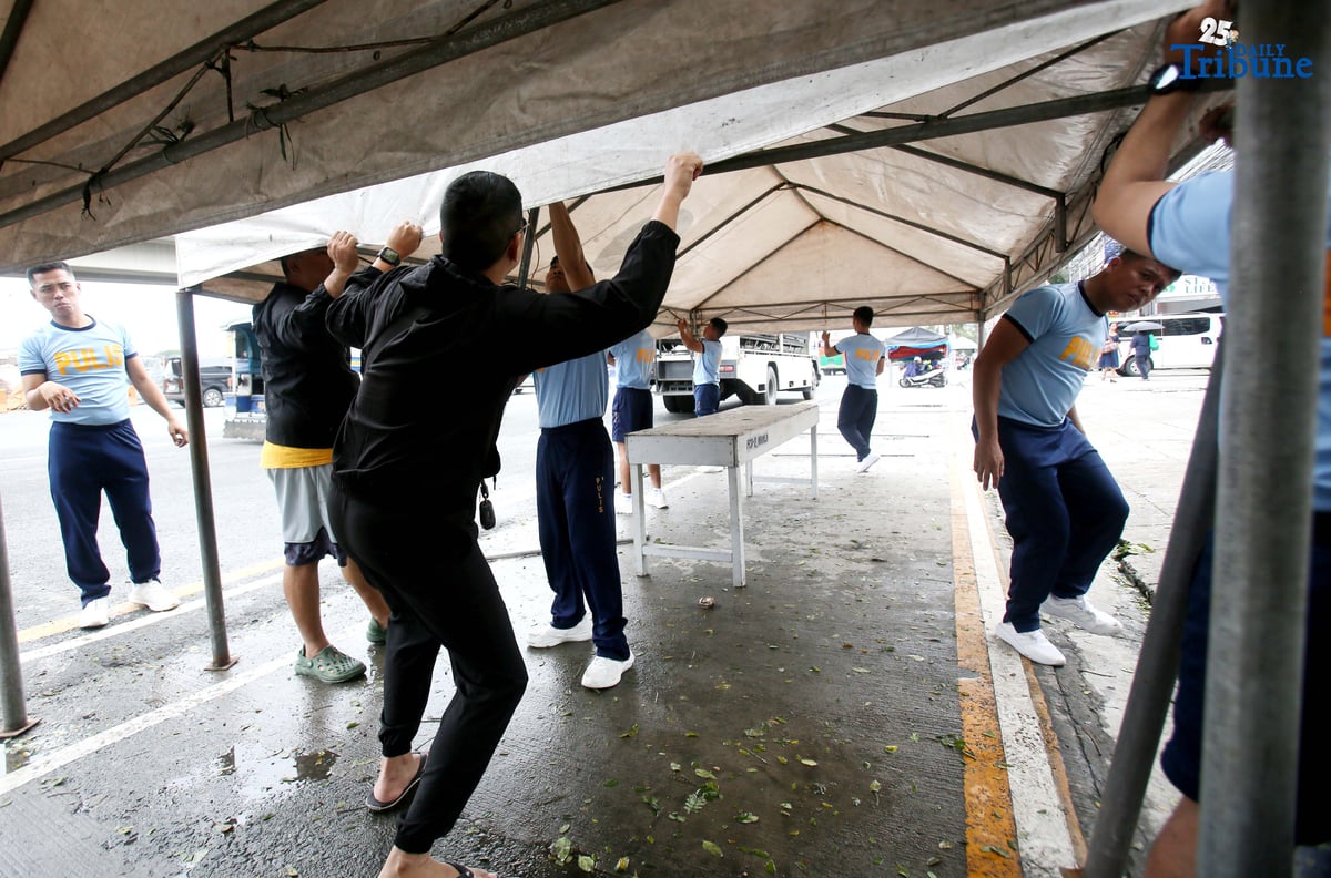 Members of the Philippine National Police (PNP) set up a tent along Commonwealth Avenue in Quezon City on Saturday, July 26, 2025, in preparation for President Ferdinand Marcos Jr.'s 4th State of the Nation Address on Monday, 28 July.