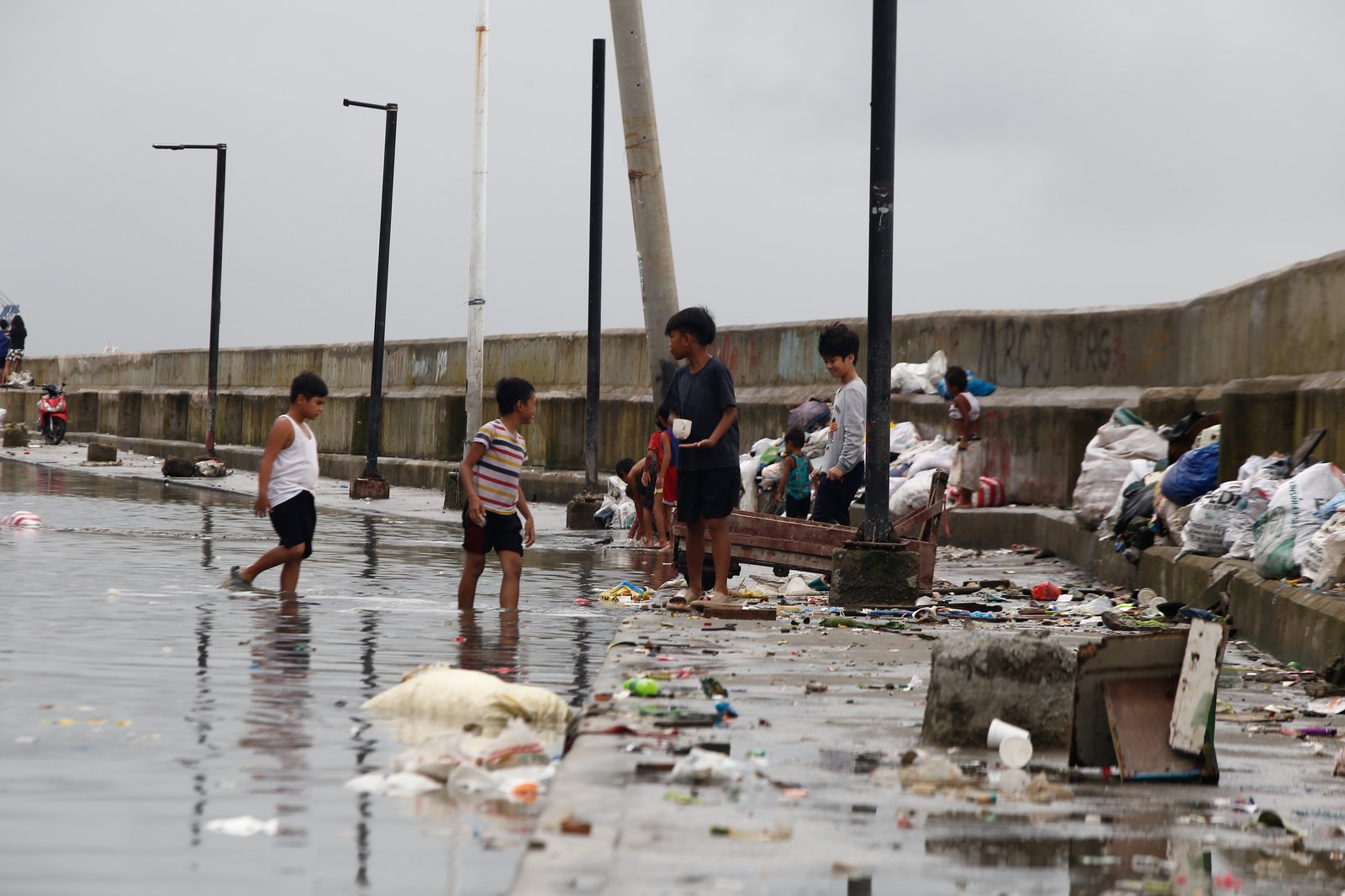 AFTER THE RAIN. Kids fly a kite at the seawall in Baseco, Manila, taking advantage of a fair weather after several days of rain brought by typhoons and southwest monsoon.