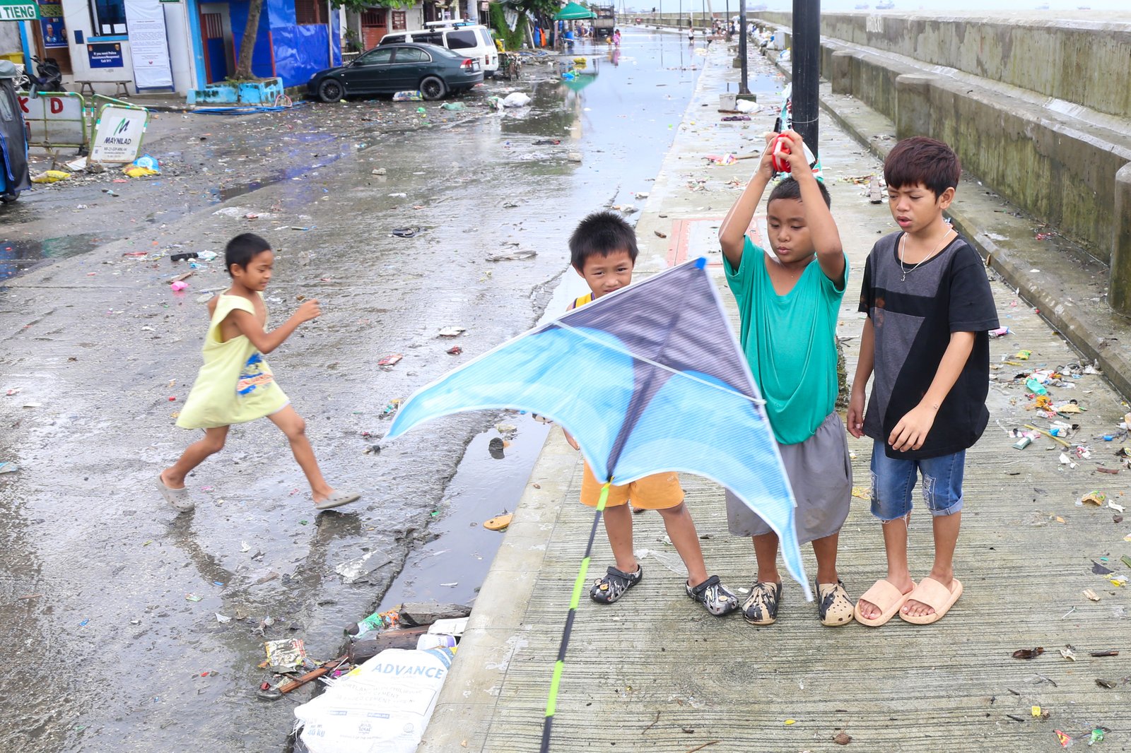 AFTER THE RAIN. Kids fly a kite at the seawall in Baseco, Manila, taking advantage of a fair weather after several days of rain brought by typhoons and southwest monsoon.