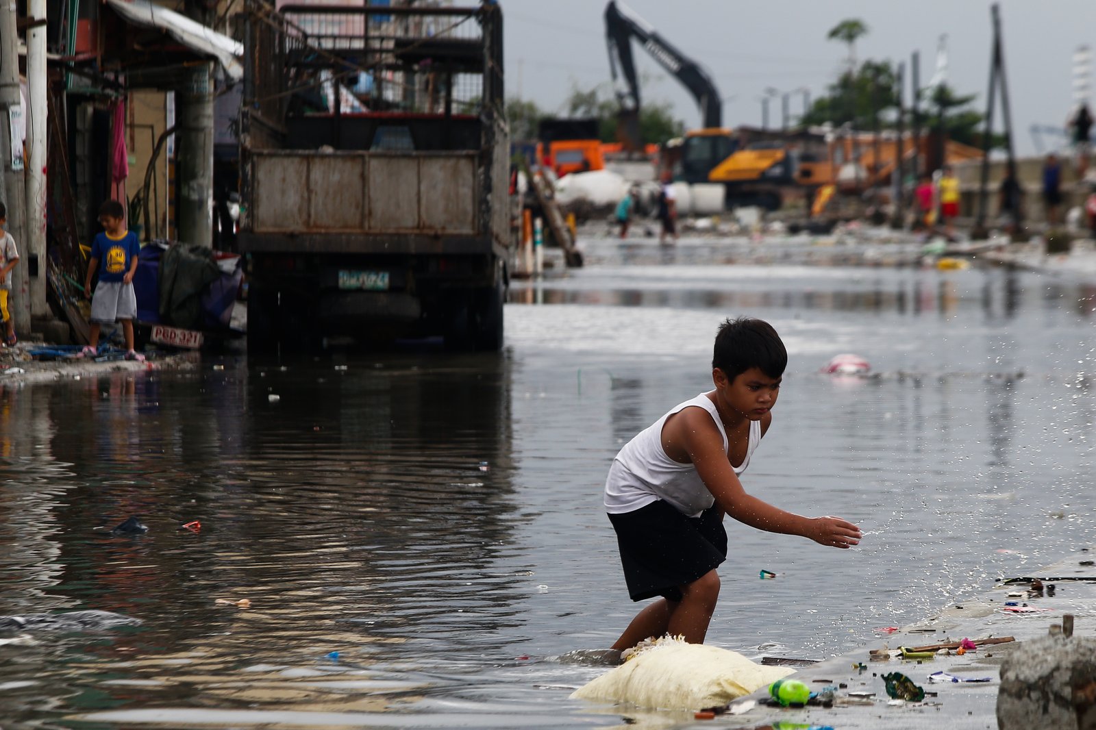 AFTER THE RAIN. Kids fly a kite at the seawall in Baseco, Manila, taking advantage of a fair weather after several days of rain brought by typhoons and southwest monsoon.