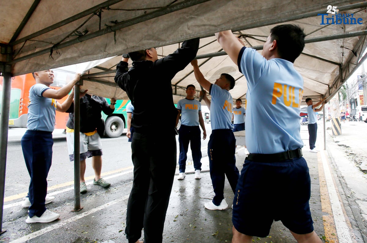 Members of the Philippine National Police (PNP) set up a tent along Commonwealth Avenue in Quezon City on Saturday, July 26, 2025, in preparation for President Ferdinand Marcos Jr.'s 4th State of the Nation Address on Monday, 28 July.