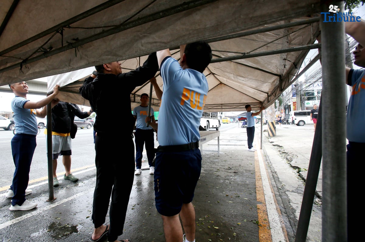 Members of the Philippine National Police (PNP) set up a tent along Commonwealth Avenue in Quezon City on Saturday, July 26, 2025, in preparation for President Ferdinand Marcos Jr.'s 4th State of the Nation Address on Monday, 28 July.