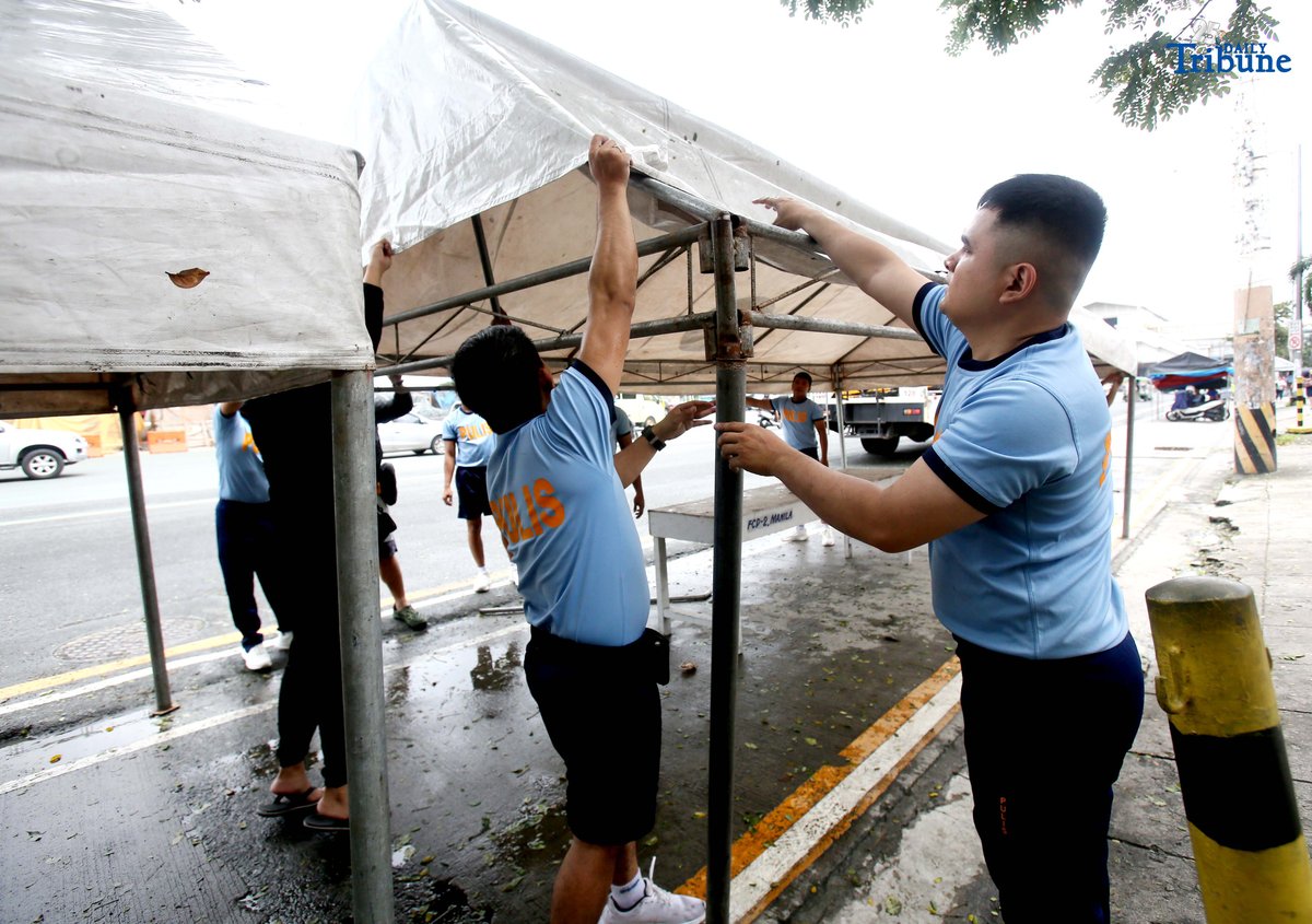 Members of the Philippine National Police (PNP) set up a tent along Commonwealth Avenue in Quezon City on Saturday, July 26, 2025, in preparation for President Ferdinand Marcos Jr.'s 4th State of the Nation Address on Monday, 28 July.