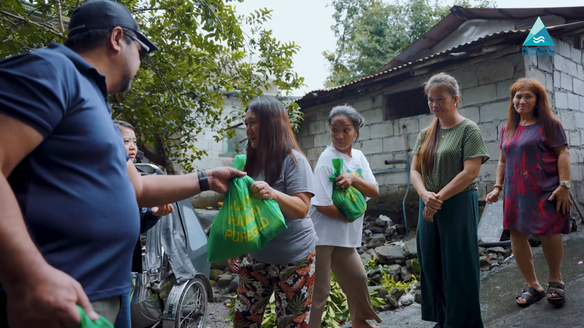 PRIME Waste Solutions-Pampanga general manager Jake Lachica (left) hands food bags to Porac residents on 23 July.
