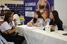 UNDERSECRETARY Margarita Gutierrez (right) and DOJAC Program Director Joan Carla Guevarra (center) render legal services to a client during a ‘Katarungan Caravan.’